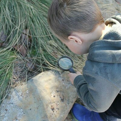 Boy investigating with magnifying glass